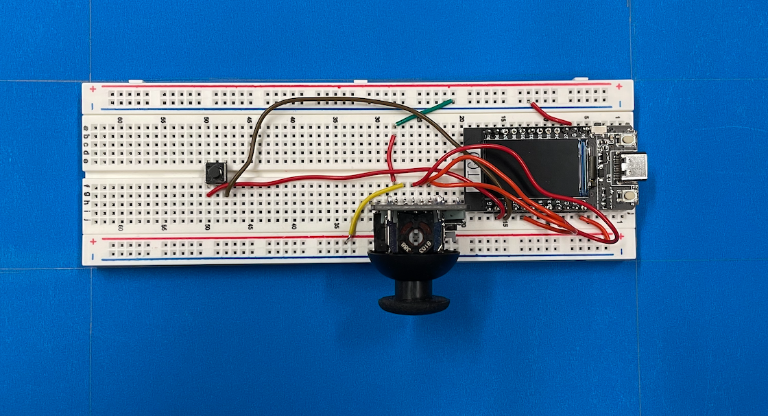 The ESP32 device in a breadboard and a joystick and a button connected.